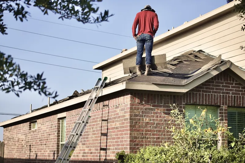 Professional roofer working on a residential roof in Le Center